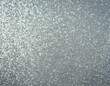A detailed view of galvanized zinc with its distinctive crystalline surface pattern, known as spangle, under soft lighting.