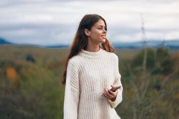 Wall Mural - Mountain Connection: A Young Woman's Adventurous Journey in Nature with her Mobile Device