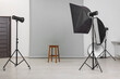 © New Africa - Empty stool surrounded by professional lighting equipment in photo studio