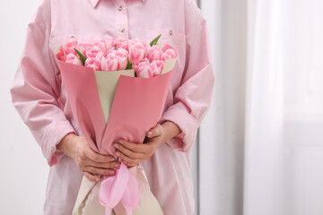 Wall Mural - Woman with bouquet of beautiful fresh tulips on blurred background, closeup