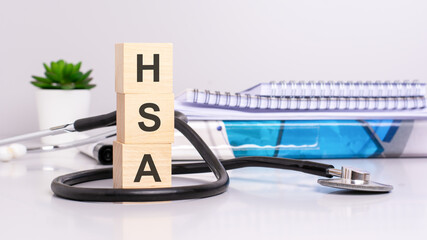 Poster - wooden blocks with the inscription HSA with stethoscope and medical document on background