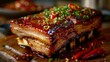 A close-up view of a succulent piece of baked pork belly, accompanied by a tangy sauce and fiery chili peppers, served on a wooden cutting board.