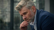 © Yuliia - Pensive sad worried sorrowful thoughtful middle-aged man senior mature business employer businessman think ponder problem solution grief put on glasses dreaming contemplate thinking in city outdoors