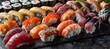 Assorted nigiri sushi and a large set of maki on slate. Variety of Japanese sushi with tuna and crab