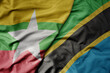 big waving national colorful flag of tanzania and national flag of myanmar .