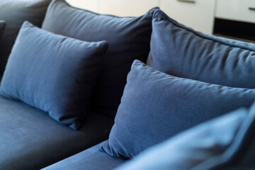 Wall Mural - Selective focus on blue soft pillows neatly folded on sofa after general cleaning