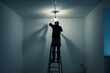 electrician on a ladder changing a light bulb in an empty apartment