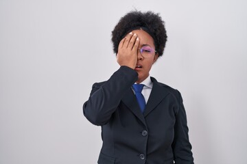 Canvas Print - Beautiful african woman with curly hair wearing business jacket and glasses yawning tired covering half face, eye and mouth with hand. face hurts in pain.