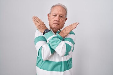 Poster - Senior man with grey hair standing over white background rejection expression crossing arms doing negative sign, angry face