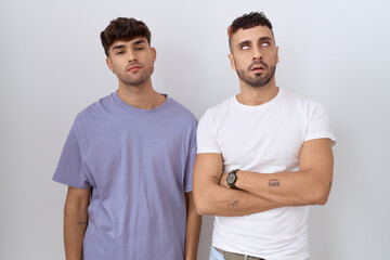 Canvas Print - Homosexual gay couple standing over white background looking sleepy and tired, exhausted for fatigue and hangover, lazy eyes in the morning.