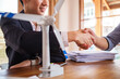 © wattana - Businesspeople shaking hands near wind turbine model after successful project of alternative energy.
