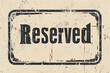 Grungy reserved sign with red splatter on textured background