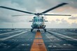 Military helicopter landing on an aircraft carrier at sea during a cloudy sunset