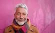© Nataliia_Trushchenko - A man with a red scarf and a brown jacket is smiling. Portrait studio shot of an attractive, healthy senior man smiling relaxedly isolated on colorful background
