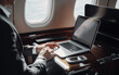 © ramona - businessman working on laptop in a private plane