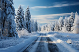 Fototapeta Na ścianę - Mountain road covered in a blanket of snow, with evergreen trees laden with white powder, creating a serene winter wonderland.