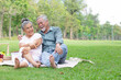 © offsuperphoto - senior couple having a picnic, embracing and looking each other in the park