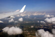 Beautiful view to the earth from flying passenger supersonic airplane window flying high in the sky above white clouds