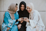 Fototapeta Nowy Jork - Three women friends going out in Dubai. Girls wearing the united arab emirates traditional abaya