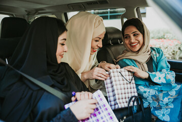 Wall Mural - Three women friends going out in Dubai. Girls wearing the united arab emirates traditional abaya