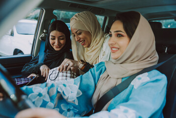 Wall Mural - Three women friends going out in Dubai. Girls wearing the united arab emirates traditional abaya