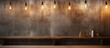 A rectangle brown hardwood table against a concrete wall with fluid amber lights hanging from the ceiling, creating warm tints and shades