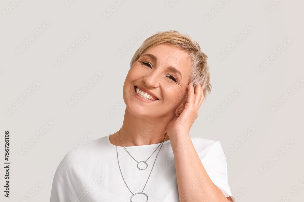 Mature blonde woman on light background, closeup