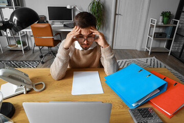 Wall Mural - Stressed young man working under deadline in office