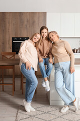 Poster - Little girl with her mom and grandmother smiling in kitchen