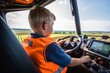 little boy sitting in combine harvester, learning to drive it, surrounded by field