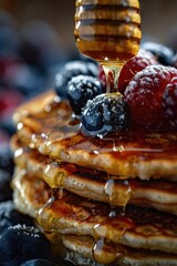 Wall Mural - A mouth-watering stack of pancakes topped with syrup and fresh berries. Perfect for breakfast or brunch menus