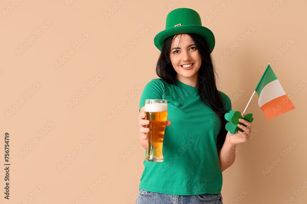 Young woman with beer and Irish flag on beige background. St. Patrick's Day celebration