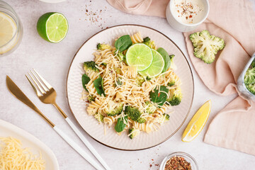 Canvas Print - Delicious fusilli pasta with broccoli, cheese and lime slices in plate on light background