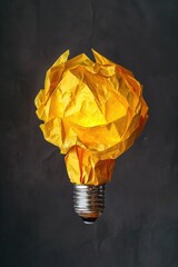 Poster - A crumpled yellow paper resting on a light bulb. Useful for concepts of creativity and ideas