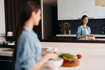 Wall Mural - Kitchen Bliss: Young Caucasian Mother and Beautiful Asian Daughter Cooking Together in a Healthy Vegetarian Diet Lifestyle