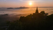 Beautiful sunrise with pagoda on the top of cliff, morning mist at Khao Na Nai Luang Dharma Park, Surat Thani province, Thailand
