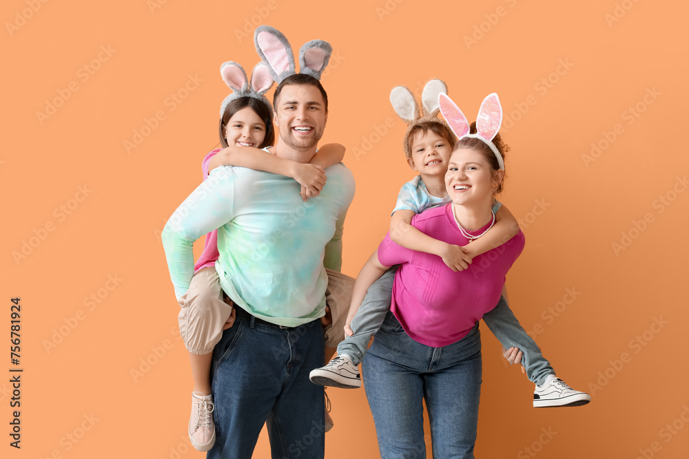 Happy family with Easter bunny ears on orange background