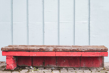 Abstract shot of concrete bench with wooden top and concrete wall in background