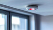 Closeup of the white smoke detector technology device placed on the ceiling in an empty room interior. House security and safety system for emergency danger and fire prevention, evacuation alarm