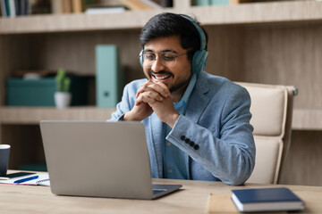 Aufkleber - Hindu manager wearing earphones engaged in video call at workplace