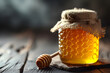 Honey jar with honey dipper or stick on wooden rustic table with copy space. Beekeeping, natural treatment for cough, strengthening the immune system and preventing colds concept.