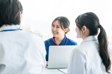 医局でカンファレンス・打ち合わせ・ミーティングする男女の看護師・技師・作業療法士・理学療法士・医師
