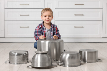 Poster - Little boy pretending to play drums on pots in kitchen