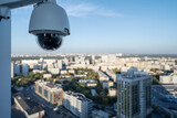 Fototapeta Natura - CCTV camera video control at the roof of building watching at cityscape