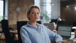 © stockbusters - Portrait confident businesswoman sitting modern office. Lady boss looking camera