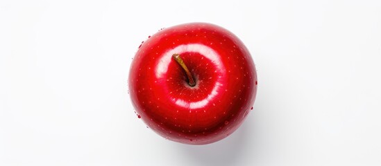 Wall Mural - A vibrant red apple rests on a pristine white surface, showcasing its natural beauty. The fruits round shape and glossy skin are highlighted in this macro photography shot