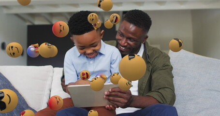 Poster - Image of emoticons over happy african american father and son using tablet on sofa