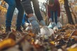 Hand of man picking up bottle into garbage bags while cleaning area in park. Volunteering, charity, people, ecology concept. Closeup volunteer collecting plastic trash in forest. World clean up  day