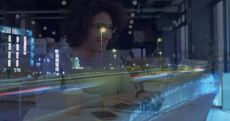 Poster - Image of smiling woman using laptop in cafe, over sped up traffic in city at night