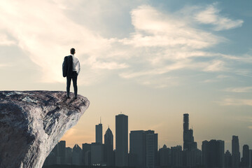 Aufkleber - Back view of businessman standing on cliff edge on bright blue sky with mock up place background. Future, success and tomorrow concept.